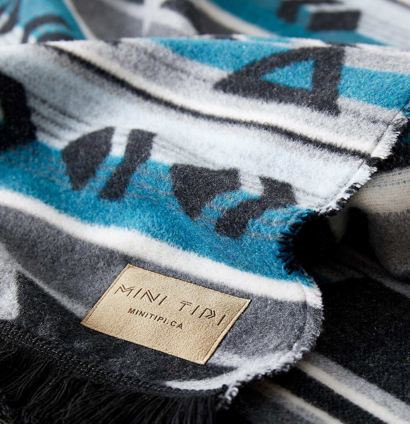 Textured fabric with a brand label saying "MINI TIPI"