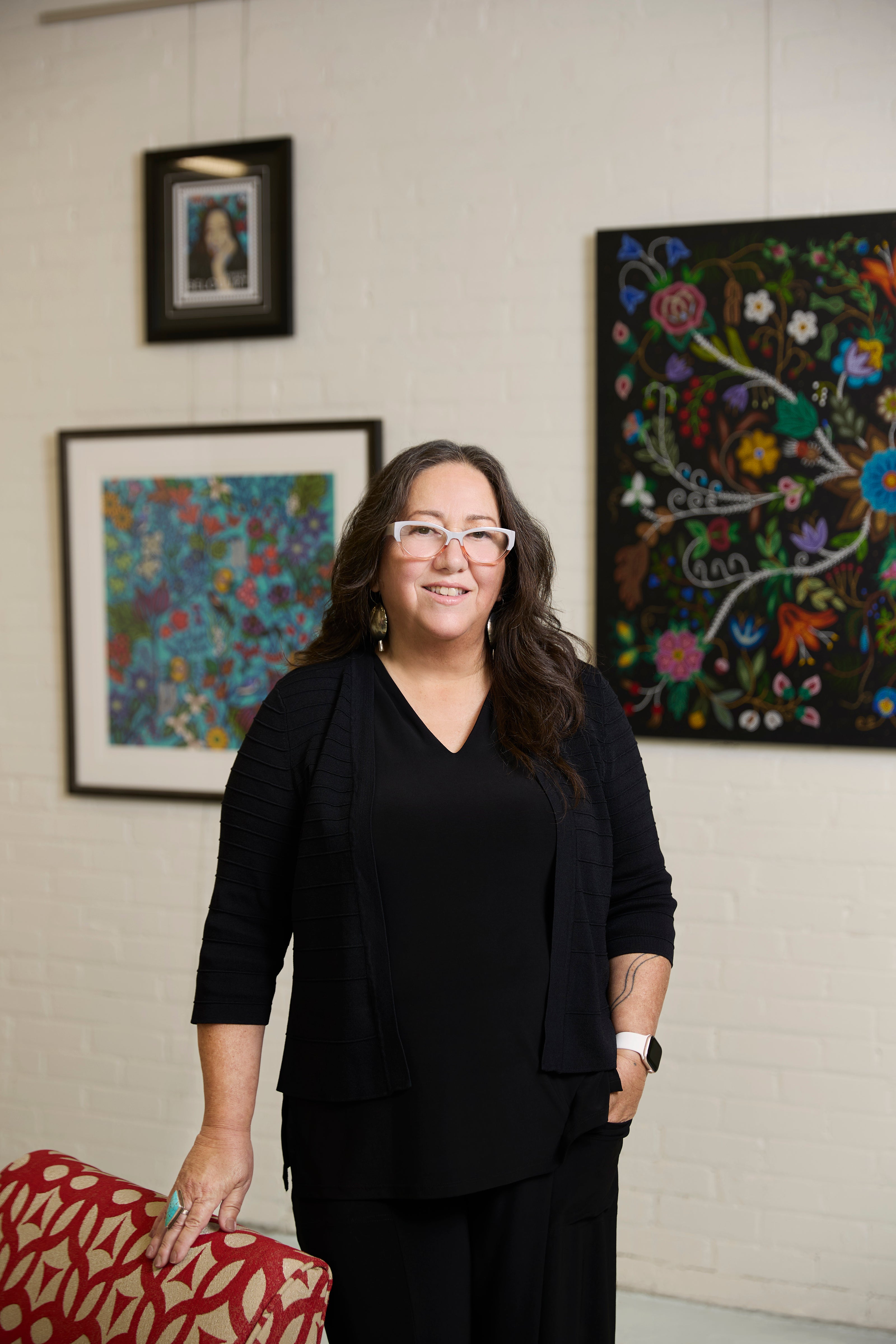 Woman standing in a room with colorful abstract art on the walls