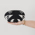 Black and white patterned pouch held by a hand on a light gray background